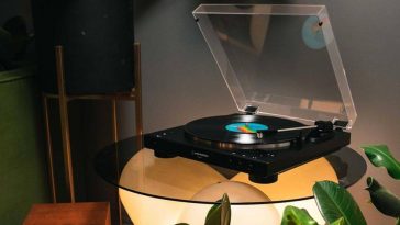 Audio-Technica AT-LP60XBT - Giradischi su tavolo di vetro in penombra
