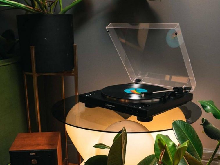 Audio-Technica AT-LP60XBT - Giradischi su tavolo di vetro in penombra