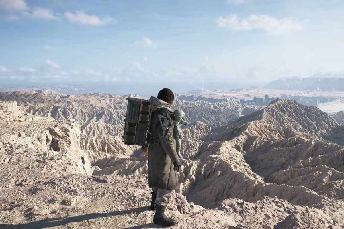 Panorama montuoso e desolato di Death Stranding 2 con Sam di spalle in primo piano.
