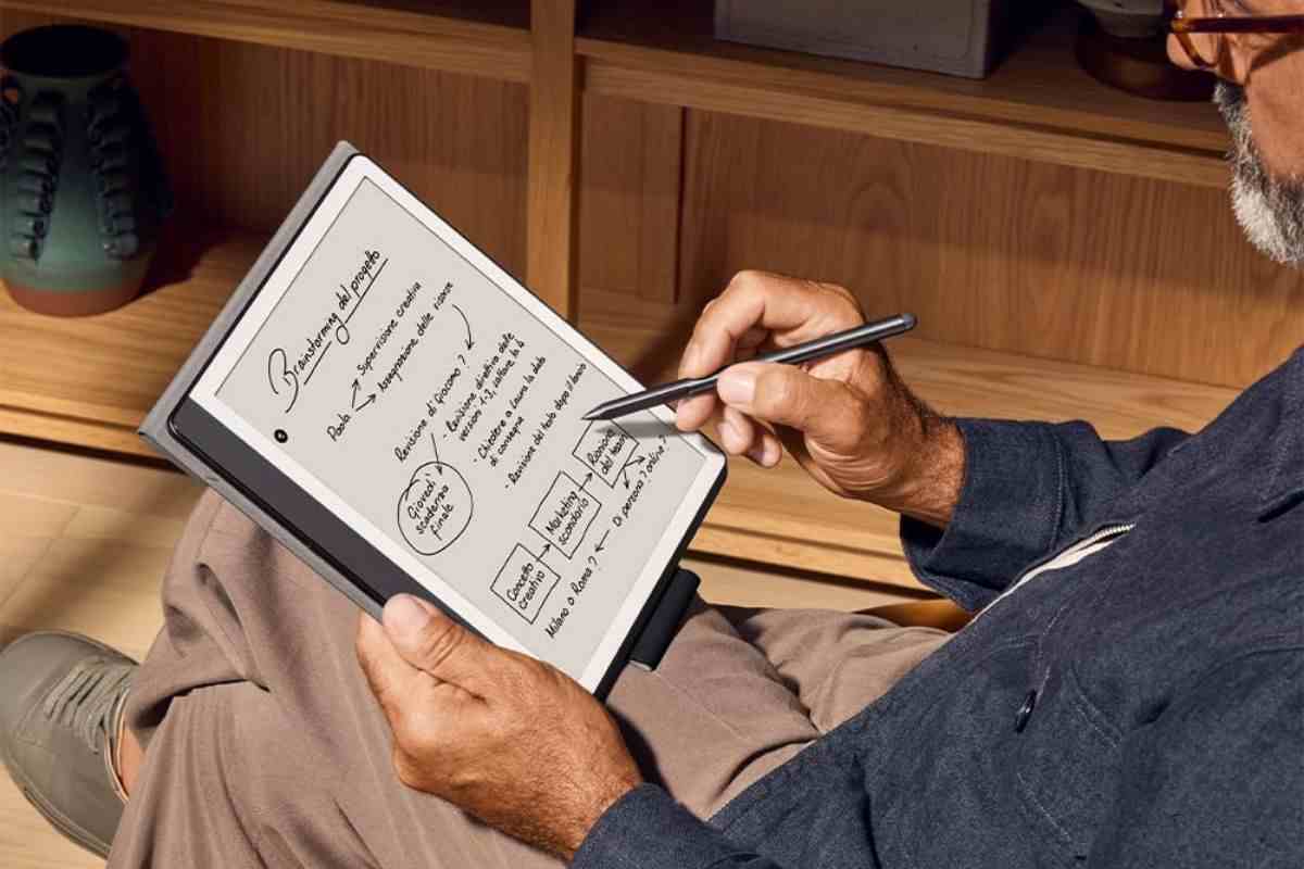 persona scrive su kindle con penna seduto