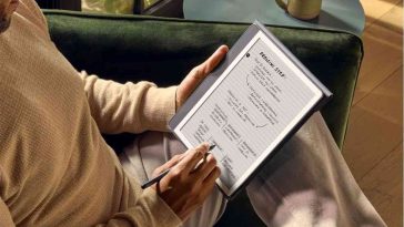 persona scrive su kindle con penna seduto, tazza