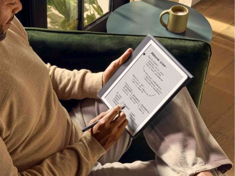 persona scrive su kindle con penna seduto, tazza