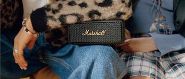 due persone sedute con una cassa bluetooth marshall sulle gambe