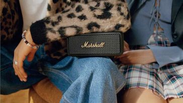 due persone sedute con una cassa bluetooth marshall sulle gambe