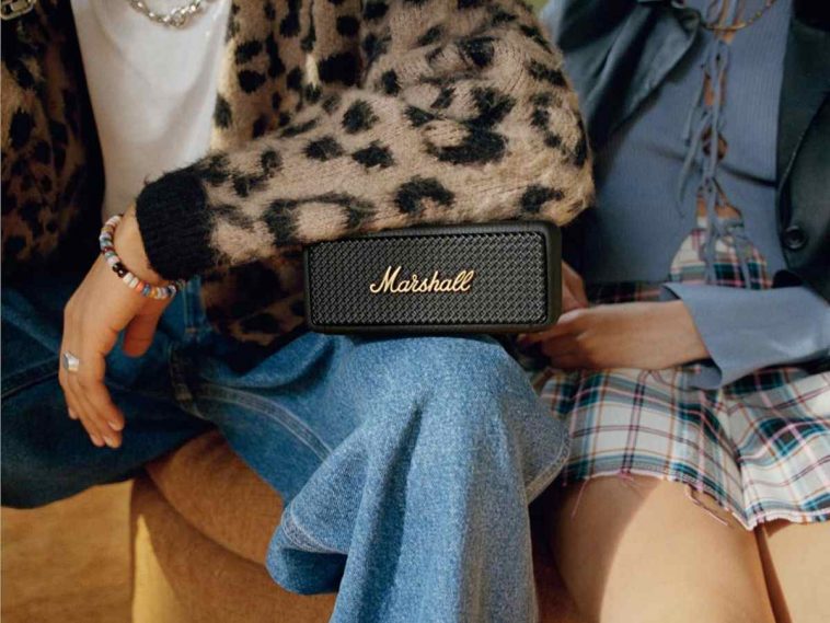 due persone sedute con una cassa bluetooth marshall sulle gambe