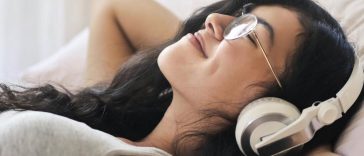 Una ragazza stesa che ascolta musica con le cuffie