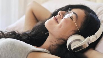 Una ragazza stesa che ascolta musica con le cuffie
