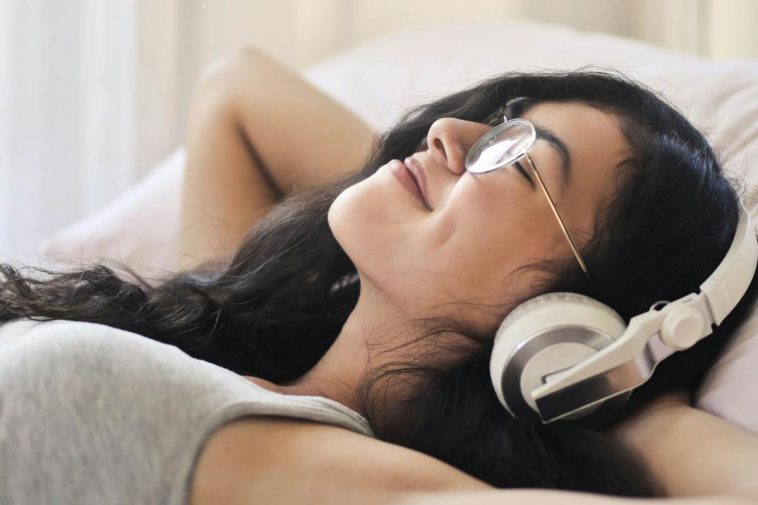 Una ragazza stesa che ascolta musica con le cuffie