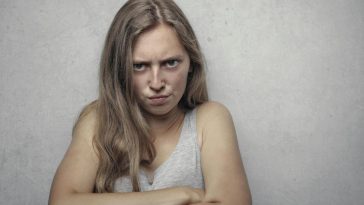 Una ragazza arrabbiata con le braccia incrociate al petto