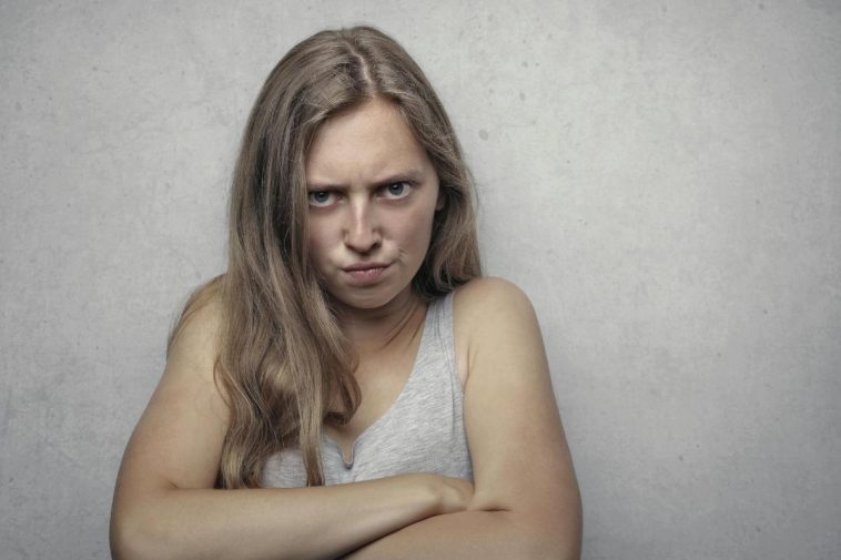 Una ragazza arrabbiata con le braccia incrociate al petto