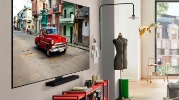 smart tv con immagine macchina rossa appesa in stanza con soundbar