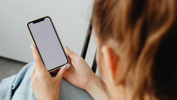 Una ragazza guarda lo schermo bianco di uno smartphone