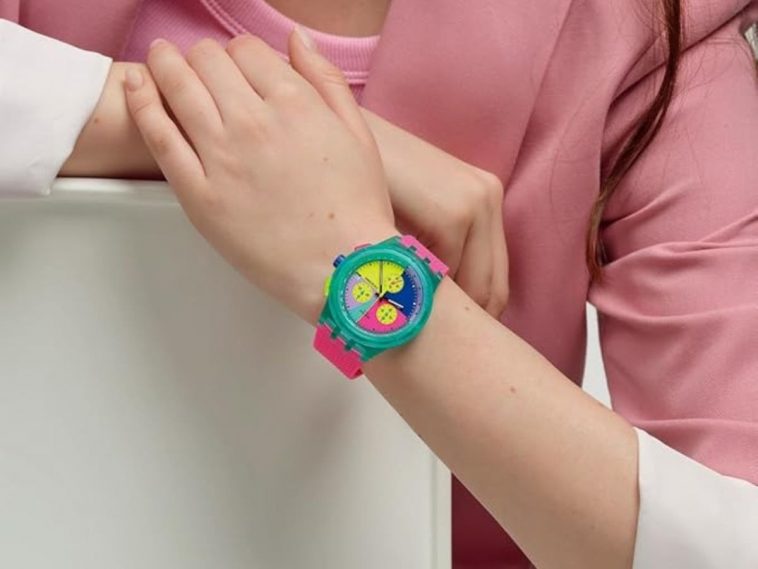 persona che indossa un neon swatch sul polso