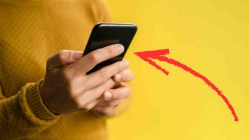 persona con telefonino e freccia