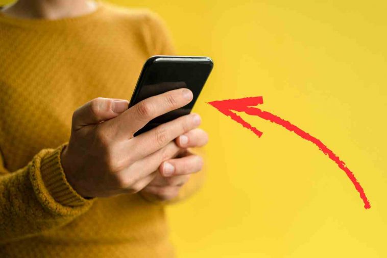 persona con telefonino e freccia