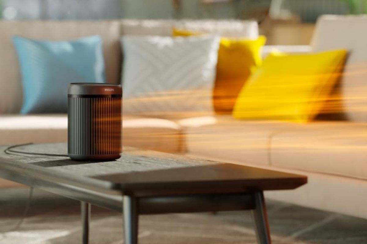 termovenitlatore philips nero su tavolino in soggiorno con linee a indcare il calore in uscita, sullo sfondo divano beige con cuscini