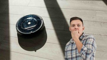 robot aspirapolvere e uomo preoccupato