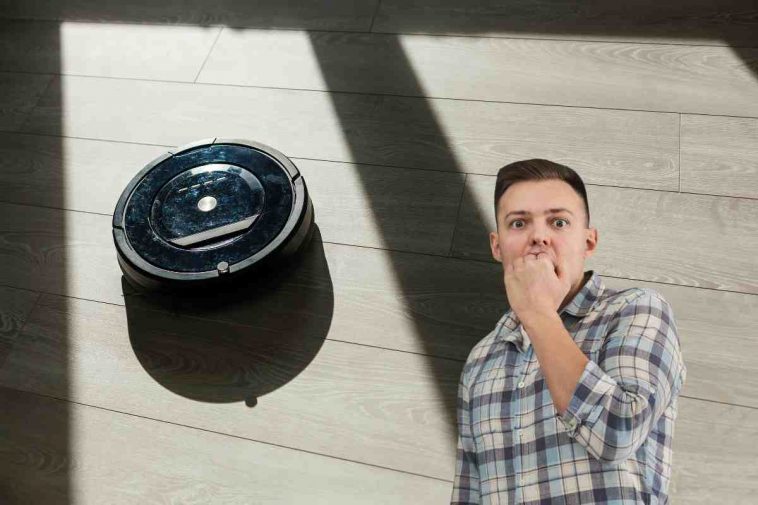 robot aspirapolvere e uomo preoccupato
