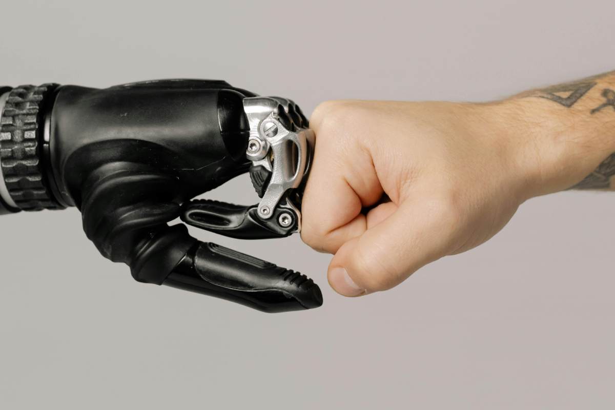 Un pugno robotico appoggiato a un pugno umano in una forma di saluto