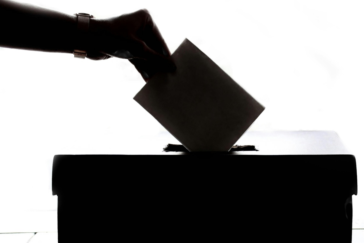 Una mano che inserisce una scheda di voto in un'urna