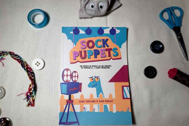 La copertina del manuale di Sock puppets circondato da bottoni, scotch, forbici e un calzino con gli occhietti