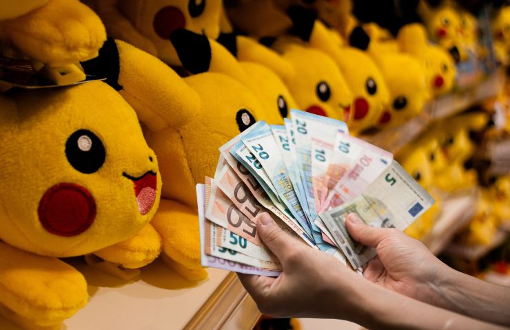 mani che allungano dei soldi a dei peluche di pikachu