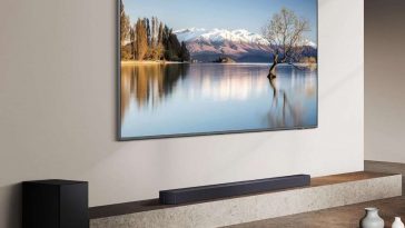 televisione appesa a muro, soundbar su mobile, subwoofer a terra