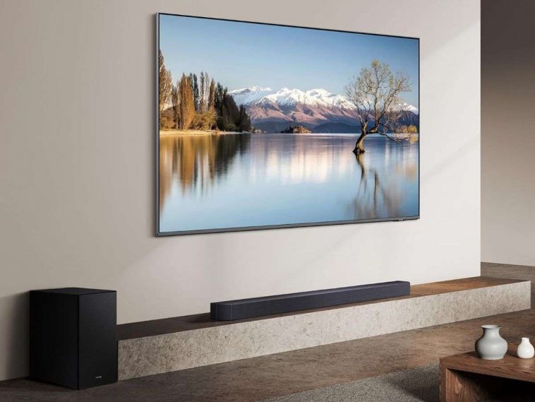 televisione appesa a muro, soundbar su mobile, subwoofer a terra