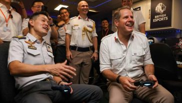 uomo con pad in mano che gioca accanto piloti e e militari