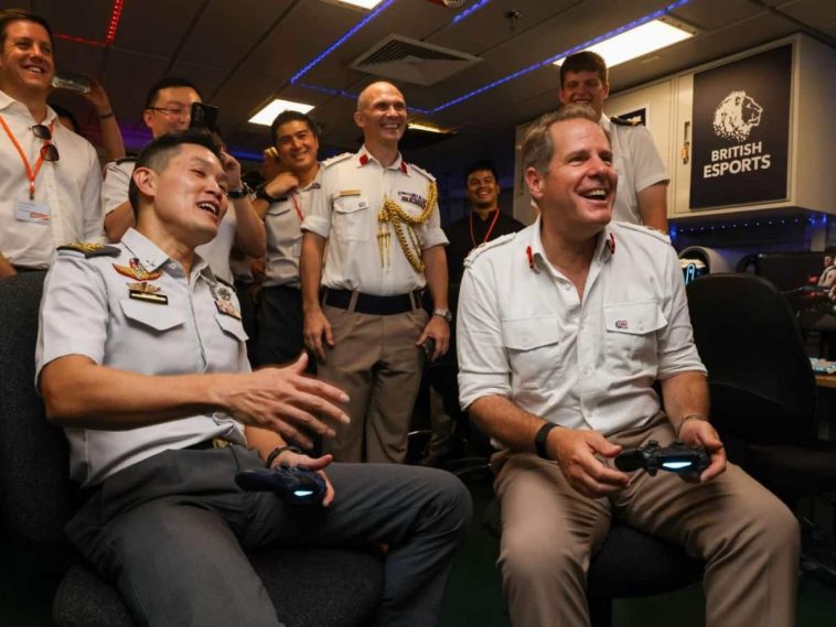 uomo con pad in mano che gioca accanto piloti e e militari