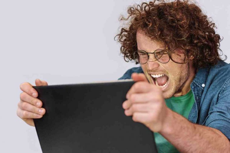 uomo che si arrabbia con il pc