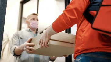 Un rider che consegna la pizza a un cliente