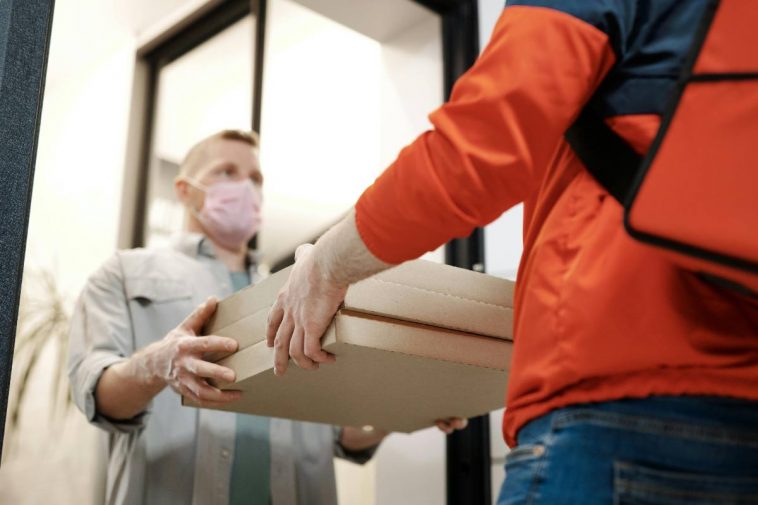 Un rider che consegna la pizza a un cliente