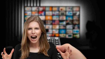 donna arrabbiata con telecomando e tv