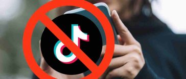 donna con smartphone e logo tiktok bannato