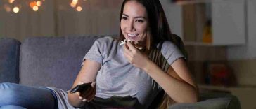 donna con popcorn guarda tv