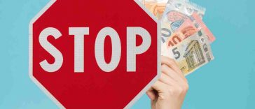 cartello stop e mano con soldi