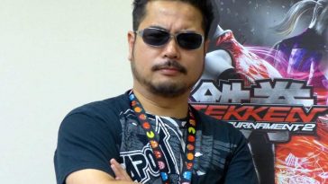 Harada uomo a braccia conserte con capelli neri e occhiali da sole