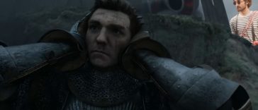 soldato che si tappa le orecchie, sullo sfondo uomo con occhiali da sole e maglietta a righe bianche e nere