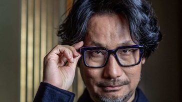 uomo giapponese con capelli brizolati che si tocca gli occhiali