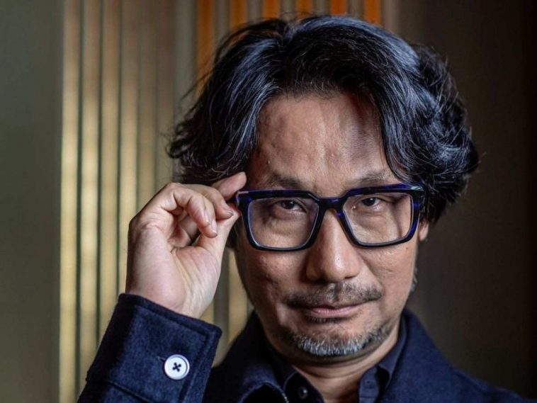 uomo giapponese con capelli brizolati che si tocca gli occhiali