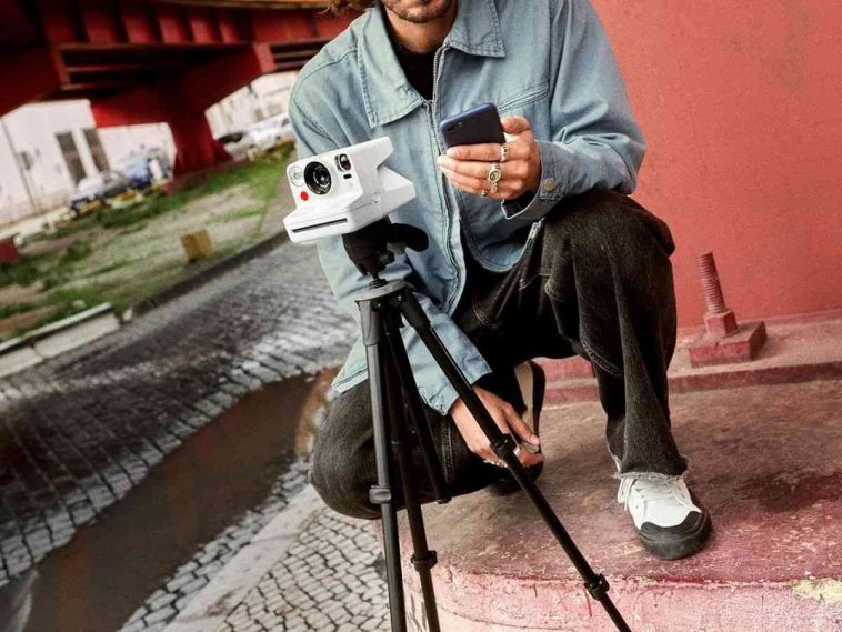 persona che tiene una polaroid sul cavalletto