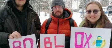 due ragazzi e una ragazza, cartelli che compongono la parola roblx