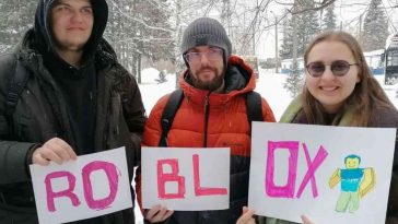 due ragazzi e una ragazza, cartelli che compongono la parola roblx