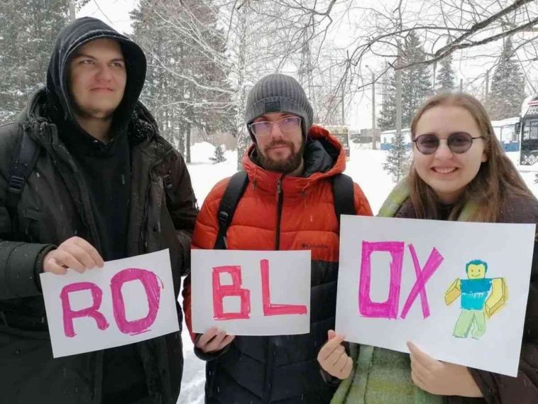due ragazzi e una ragazza, cartelli che compongono la parola roblx