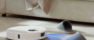 robotaspirapolvere bianco, luce laser, divano, ciabatte