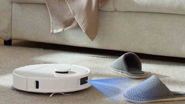 robotaspirapolvere bianco, luce laser, divano, ciabatte