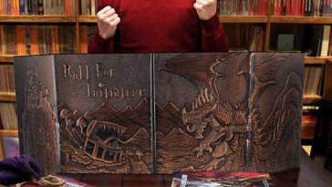 ragazzo con maglietta rossa davanti a schermo del master con ilustrazione dragon e mimic, cartelle da giocatori