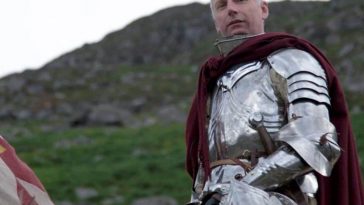 uomo con capelli bianchi con corazza da cavaliere su cavallo