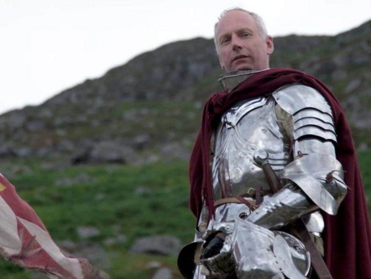 uomo con capelli bianchi con corazza da cavaliere su cavallo